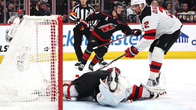 Sebastian Aho #20 of the Carolina Hurricanes scores a goal past Brian Dumoulin #2 and Jacob Markstrom #25 of the New Jersey Devils during the second period in Game Five of the First Round of the 2025 Stanley Cup Playoffs at Lenovo Center on April 29, 2025 in Raleigh, North Carolina.